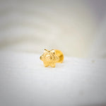 Front view of star-shaped 18K nose pin gold placed on a soft white surface highlighting its detailed floral carving