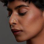 Woman wearing a delicate 18K nose pin gold showcasing a refined and elegant everyday look