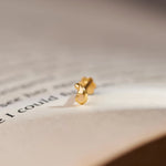 Gold swirl teardrop-shaped stud earring, close-up