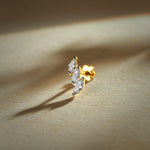Gold nose pin with double leaf design featuring sparkling stones set in a polished gold base on a soft neutral background