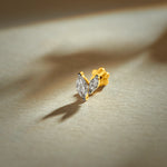 Nose pin gold with leaf-shaped design featuring sparkling stones set in a polished gold base on a soft neutral background