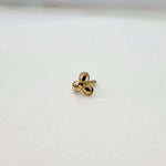 Close up view of a tiny 18K nose pin gold placed on a white surface highlighting its compact size and polished finish