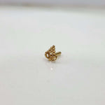Close-up of tiny 18K gold nose pin on a white background highlighting its fine detailing