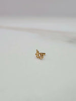 Front view close up of a small 18K nose pin gold placed on a white surface showing compact size and fine detailing