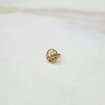 Front view of a small round 18K gold nose pin placed on a white background showcasing fine detailing and compact size