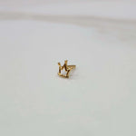 Side view of a small crown motif gold nose pin placed on a white surface showing its compact size and finish