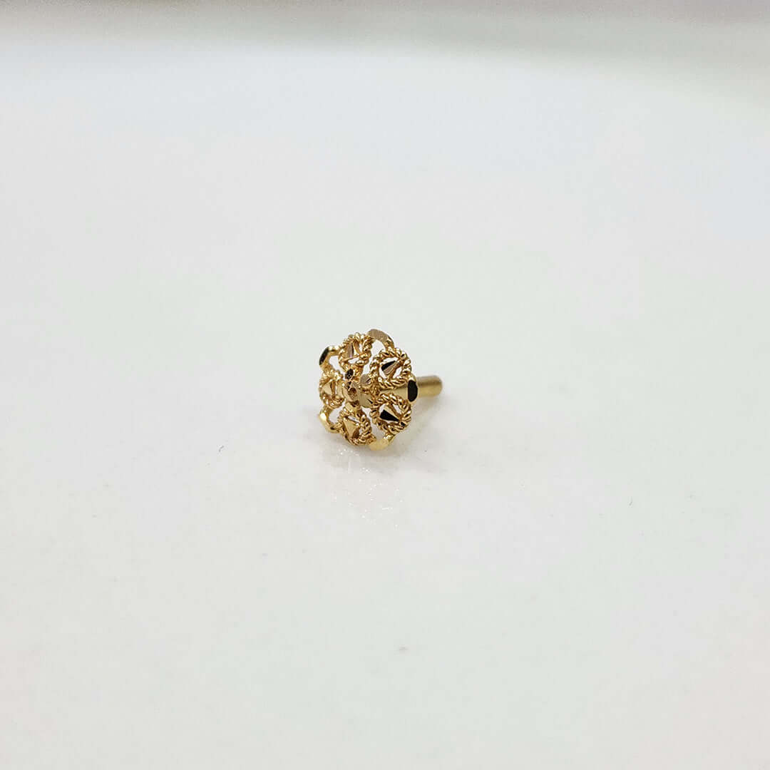 Front view of small floral gold nose pin on a white background displaying its compact size and intricate design