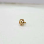 Front view of floral gold nose pin on a white background displaying its small size and fine detailing