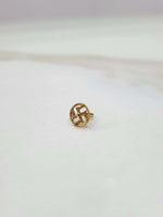 Close-up of a tiny 18K nose pin gold placed on a white surface showing fine detailing and compact finish