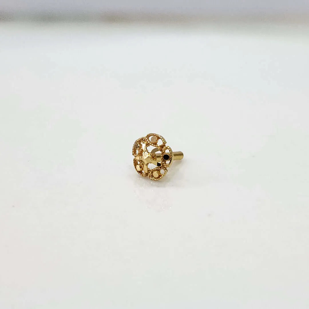 Front view of tiny floral 18K nose pin gold placed on a white surface highlighting its fine detailing