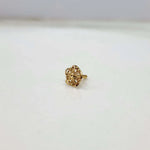 Front view of compact floral gold nose pin on a white background displaying its fine detailing and size