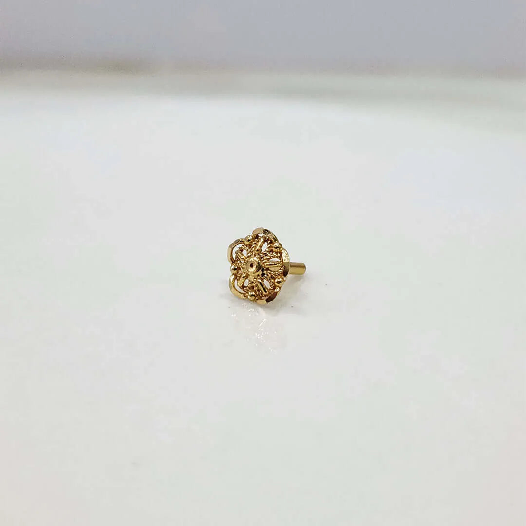 Front view of compact floral gold nose pin on a white background displaying its fine detailing and size