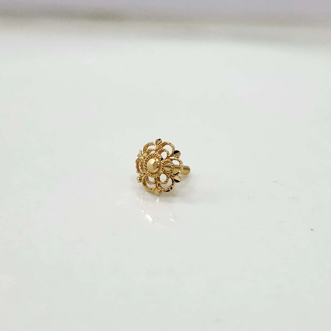 Small floral 18K nose pin gold placed on a white surface showing its fine handcrafted detailing