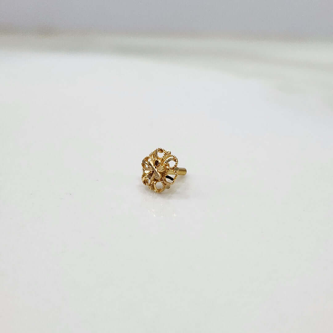 Front view of tiny floral 18K nose pin gold placed on a white background highlighting its delicate detailing