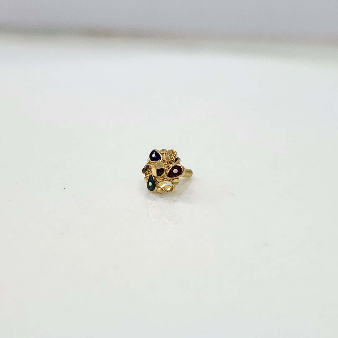 Small floral 18K nose pin gold placed on a white surface highlighting delicate detailing