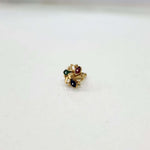 Small multicolour 18K nose pin gold placed on a white surface showing its delicate detailing