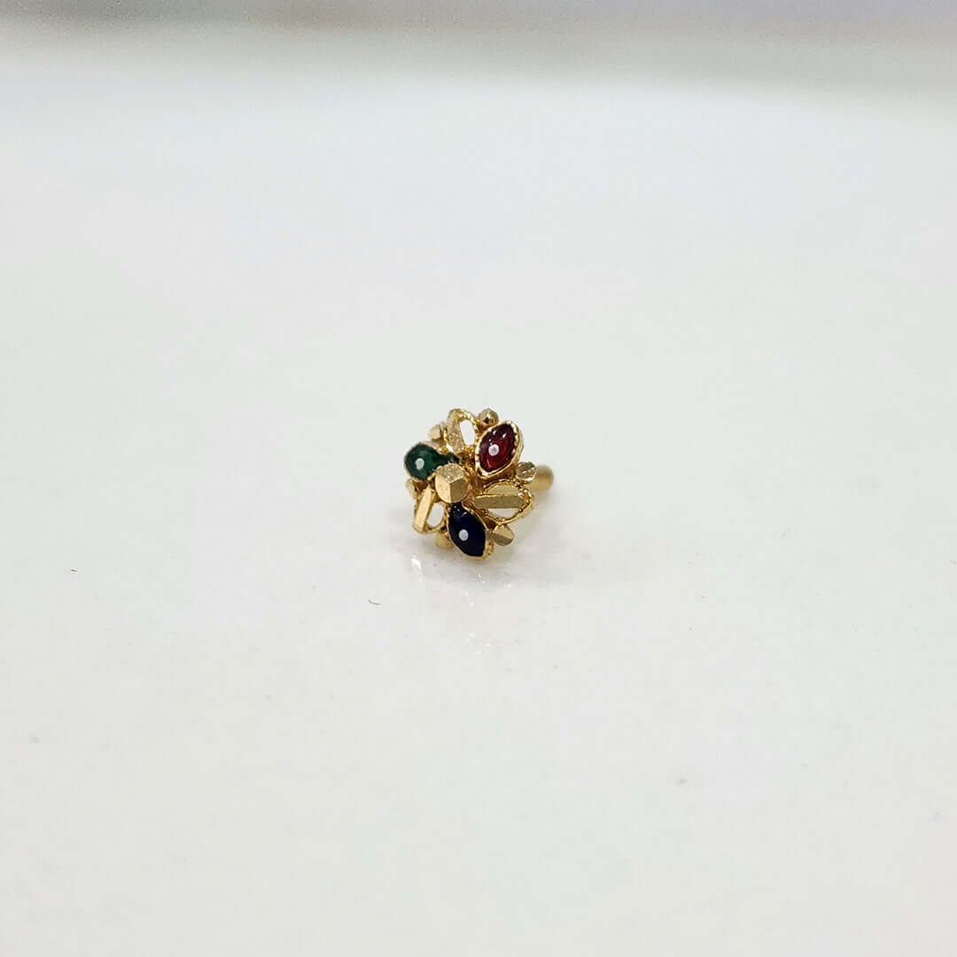 Small multicolour 18K nose pin gold placed on a white surface showing its delicate detailing