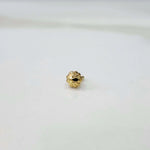 Slight angled view of a delicate gold nose pin placed on a white surface showing its lightweight everyday design