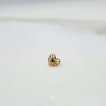 Side view of a delicate 18K nose pin gold on a white surface highlighting lightweight design and smooth finish
