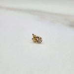 Side view of a delicate 18K nose pin gold on a white background highlighting its curved design and polished finish