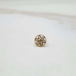 Front view of an 18K gold round nose pin on a white background displaying its floral-inspired design