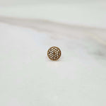 Side view of a tiny round 18K nose pin gold on a white background showing its compact size and subtle shine