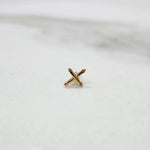 Tiny cross gold nose pin placed on a white surface showing delicate craftsmanship