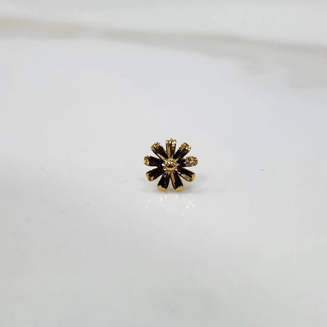 Angled view of the daisy motif gold nose pin on a white background emphasizing depth and craftsmanship