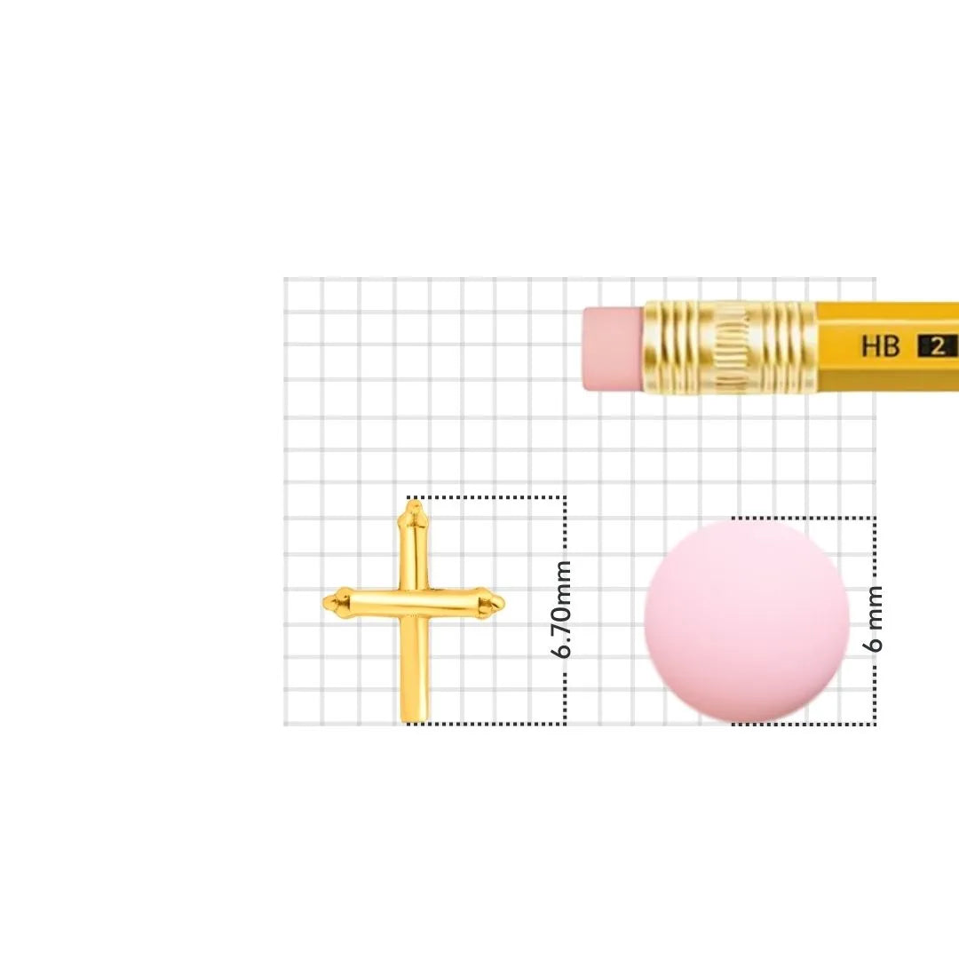 Gold cross nose pin placed on a measurement grid with pencil showing accurate size and dimensions