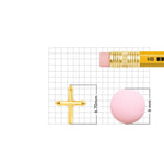 Gold cross nose pin placed on a measurement grid with pencil showing accurate size and dimensions