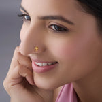 Woman wearing stylish gold nose pin design showcasing floral elegance and traditional indian look