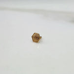 Side angle view of hexagon motif 18K gold nose pin on a white background emphasizing thickness and profile