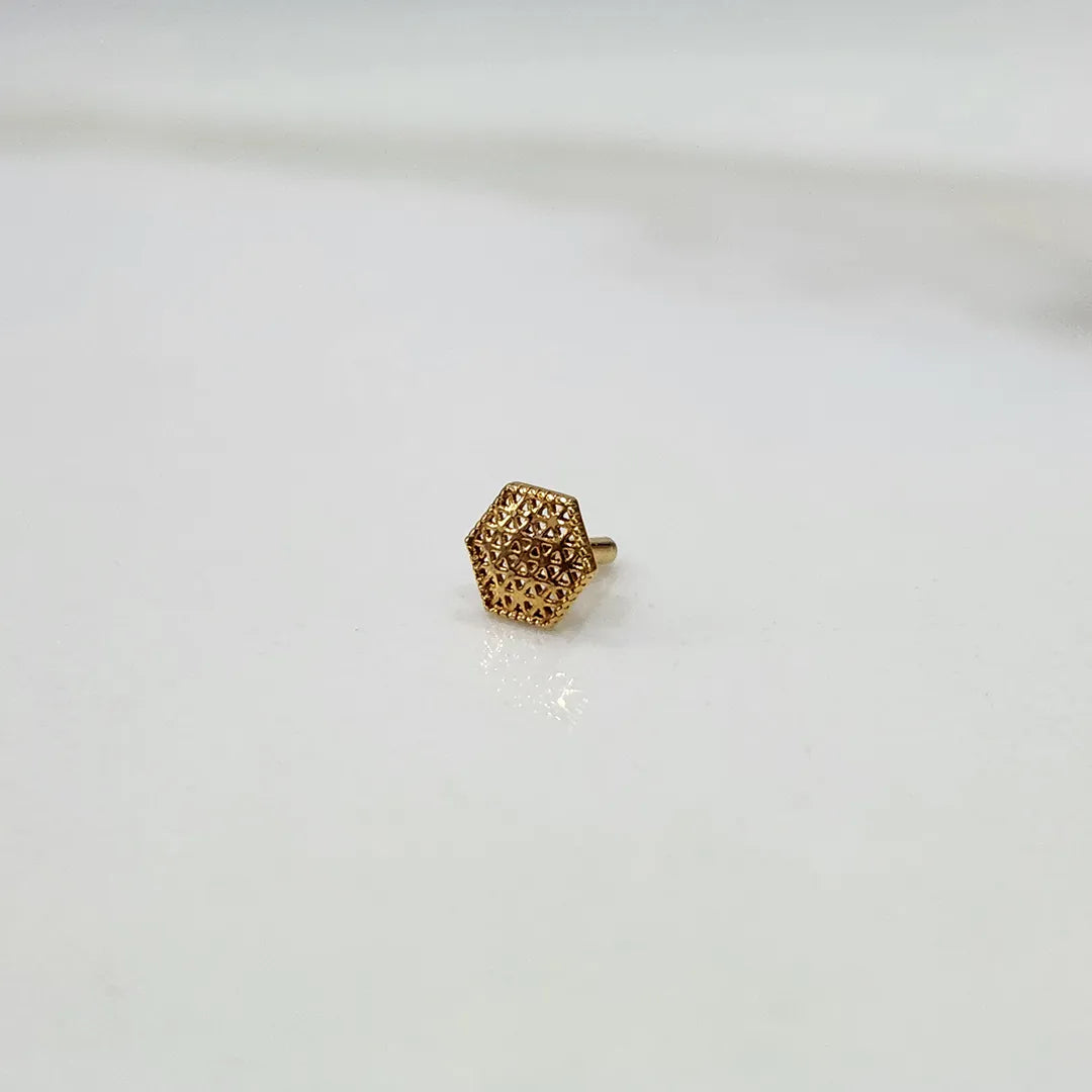 Side angle view of hexagon motif 18K gold nose pin on a white background emphasizing thickness and profile