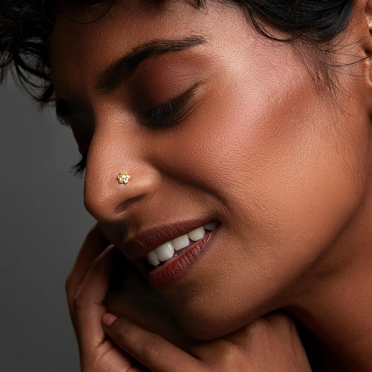 Woman wearing a delicate gold nose pin in side profile showcasing a soft elegant everyday look