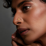 Side profile of a woman wearing a minimal gold nose pin showcasing an elegant and natural look