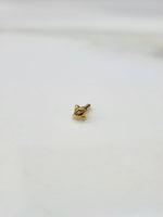 Front view of minimal 18K gold nose pin on a white background showing its petite size