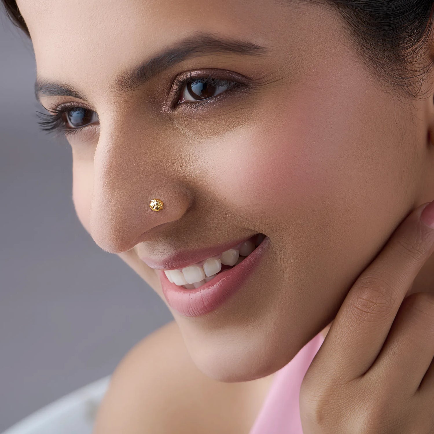 Woman wearing a tiny gold nose pin showcasing a subtle and elegant look