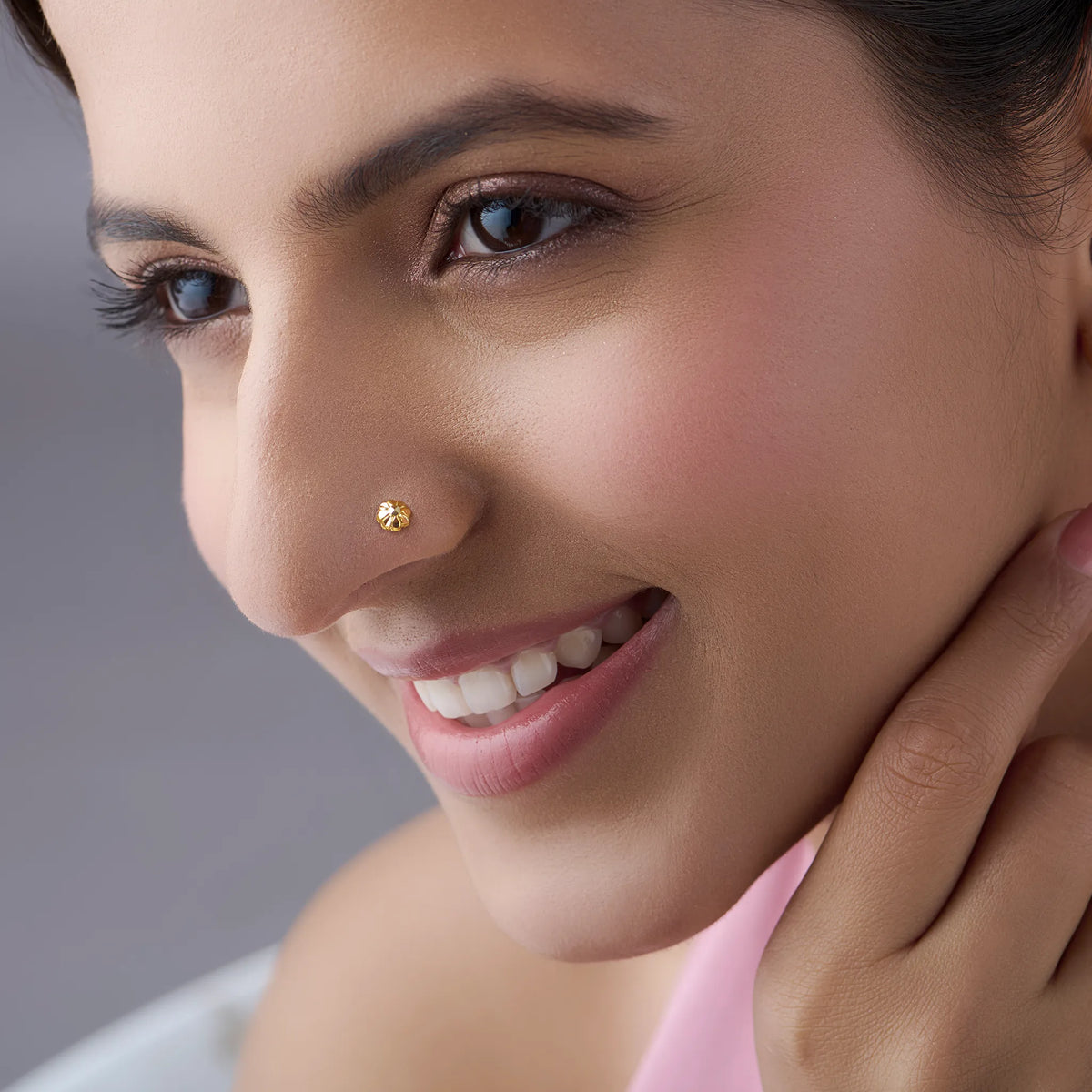 Woman wearing a tiny gold nose pin showcasing a subtle and elegant look