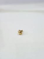 Front view of a tiny gold nose pin on a plain white background showing its compact size
