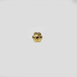 Angled view of flower inspired gold nose pin on a neutral background showing depth and craftsmanship