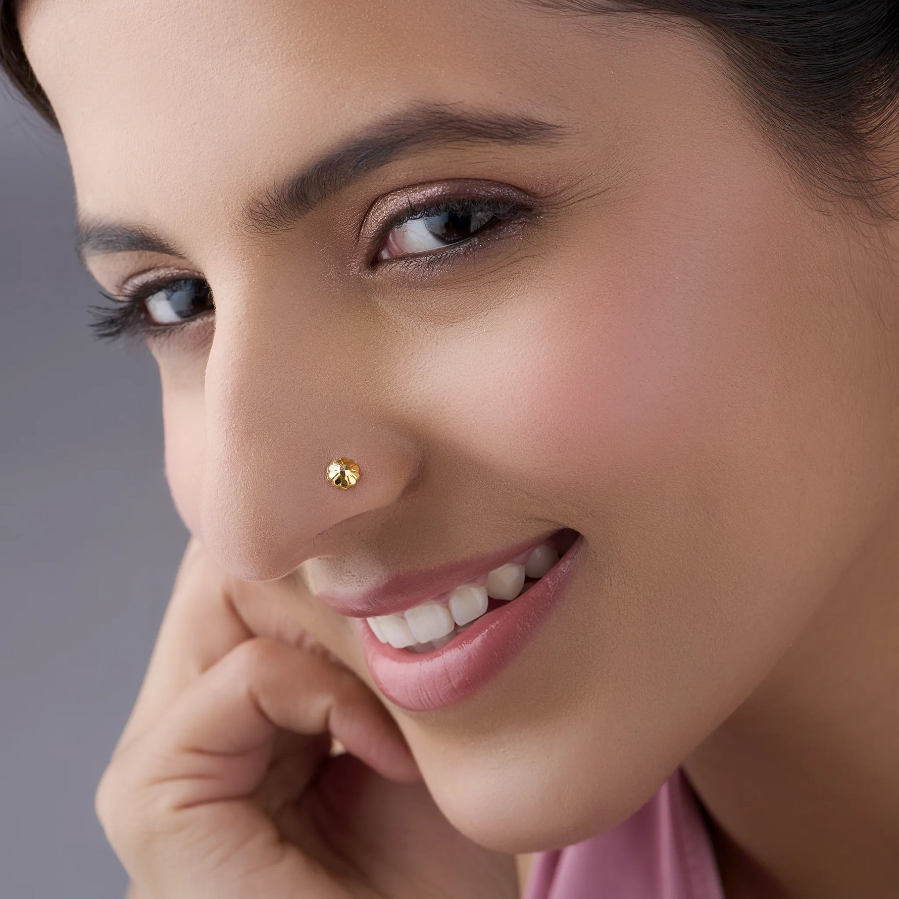 Woman wearing beautiful gold nose pin showcasing delicate floral motif and traditional elegance