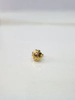 Small Swastik Bloom 18K Nose Pin Gold placed on white surface showing intricate floral detailing