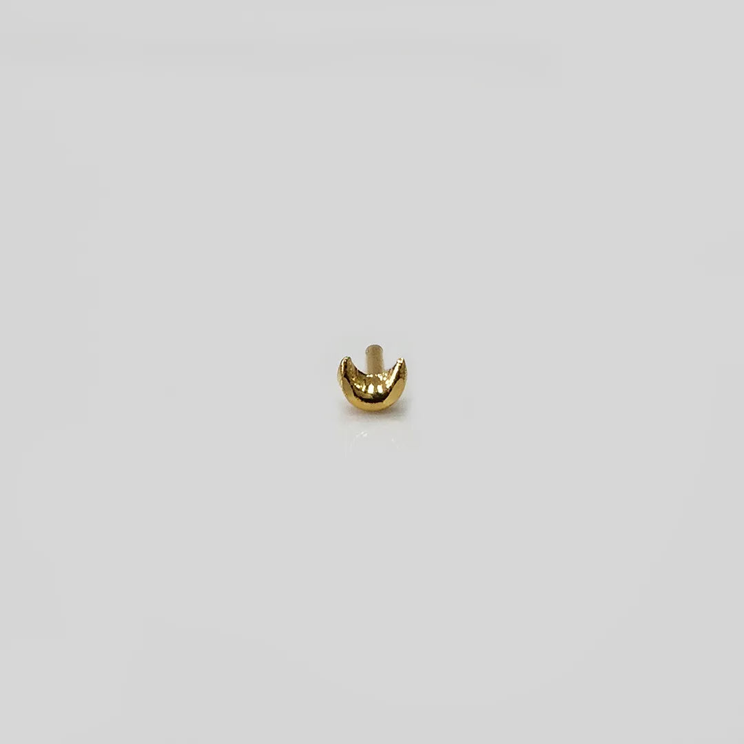 Side angle view of crescent gold nose pin showing curved minimalist form and fine finish
