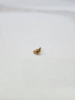 Tiny gold nose pin placed on a white background showing its compact size and delicate design
