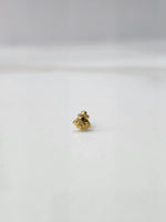 Tiny gold nose pin placed on a white background in a front view showing its minimal size and detailing