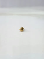 Side view of a delicate gold nose pin on a white surface highlighting its neat finish and lightweight form