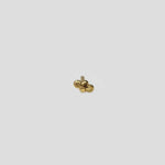 Angled view of delicate 18K gold nose pin on a light grey background showing profile shape