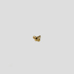 Close up of tiny twin knot design 18K gold nose pin on a light grey background showing minimalist detailing