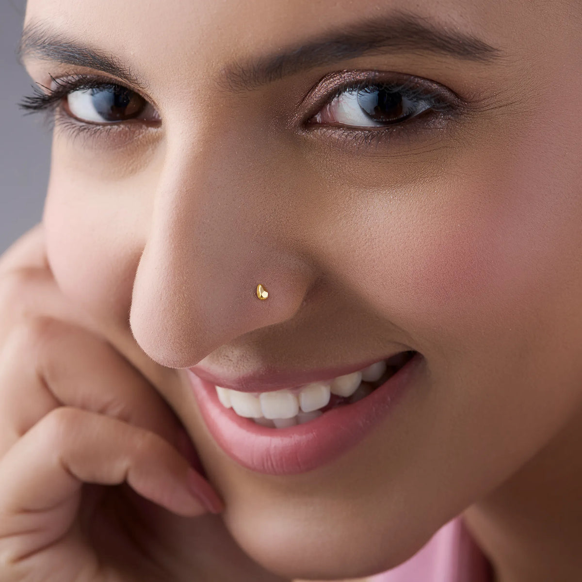 Woman wearing teardrop gold nose pin highlighting its minimal and classy everyday style