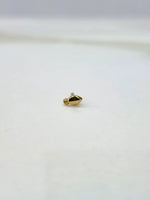Side view of a lightweight gold nose pin on a white surface showing its compact size and fine detailing